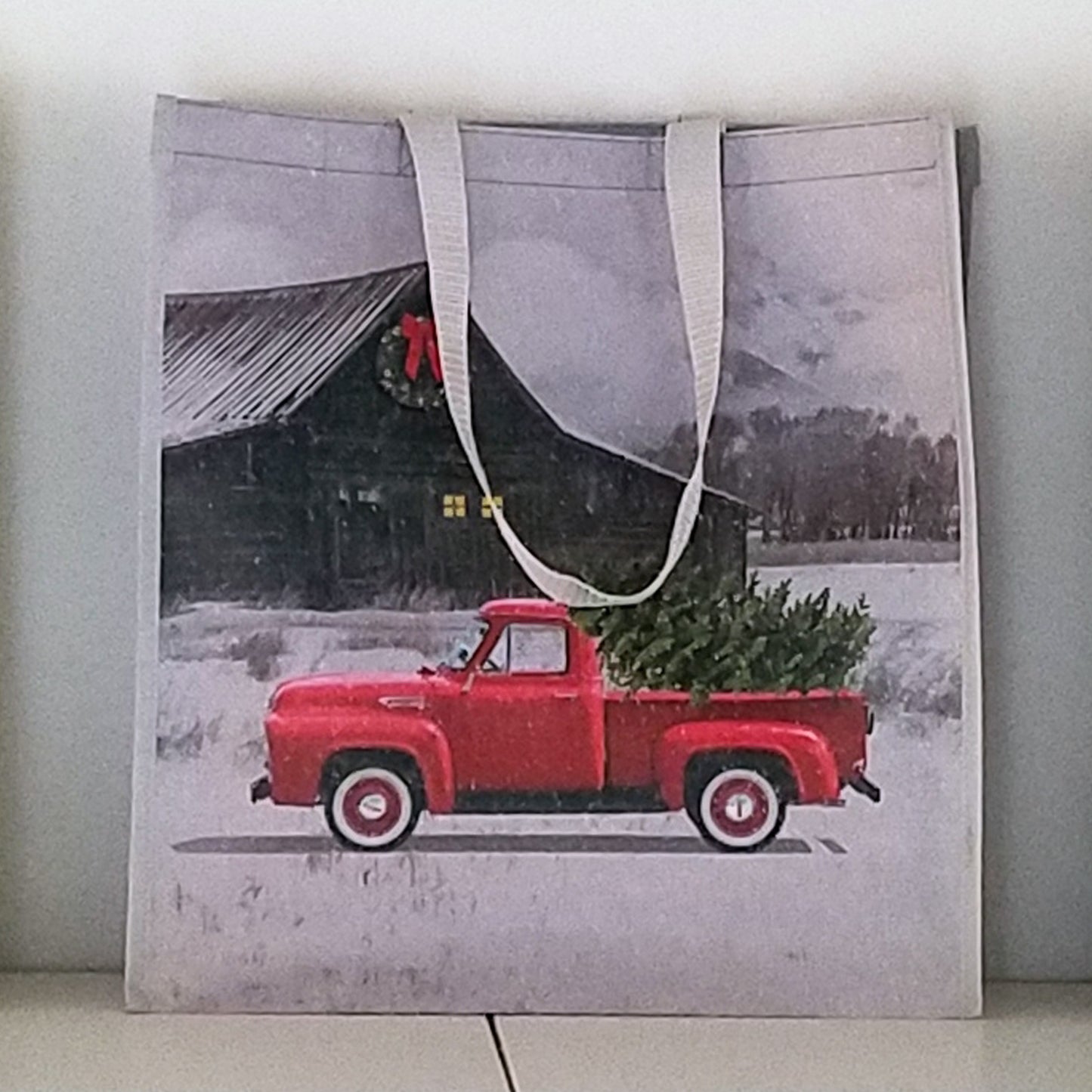 Bolsa de compras navideña con forma de camión rojo